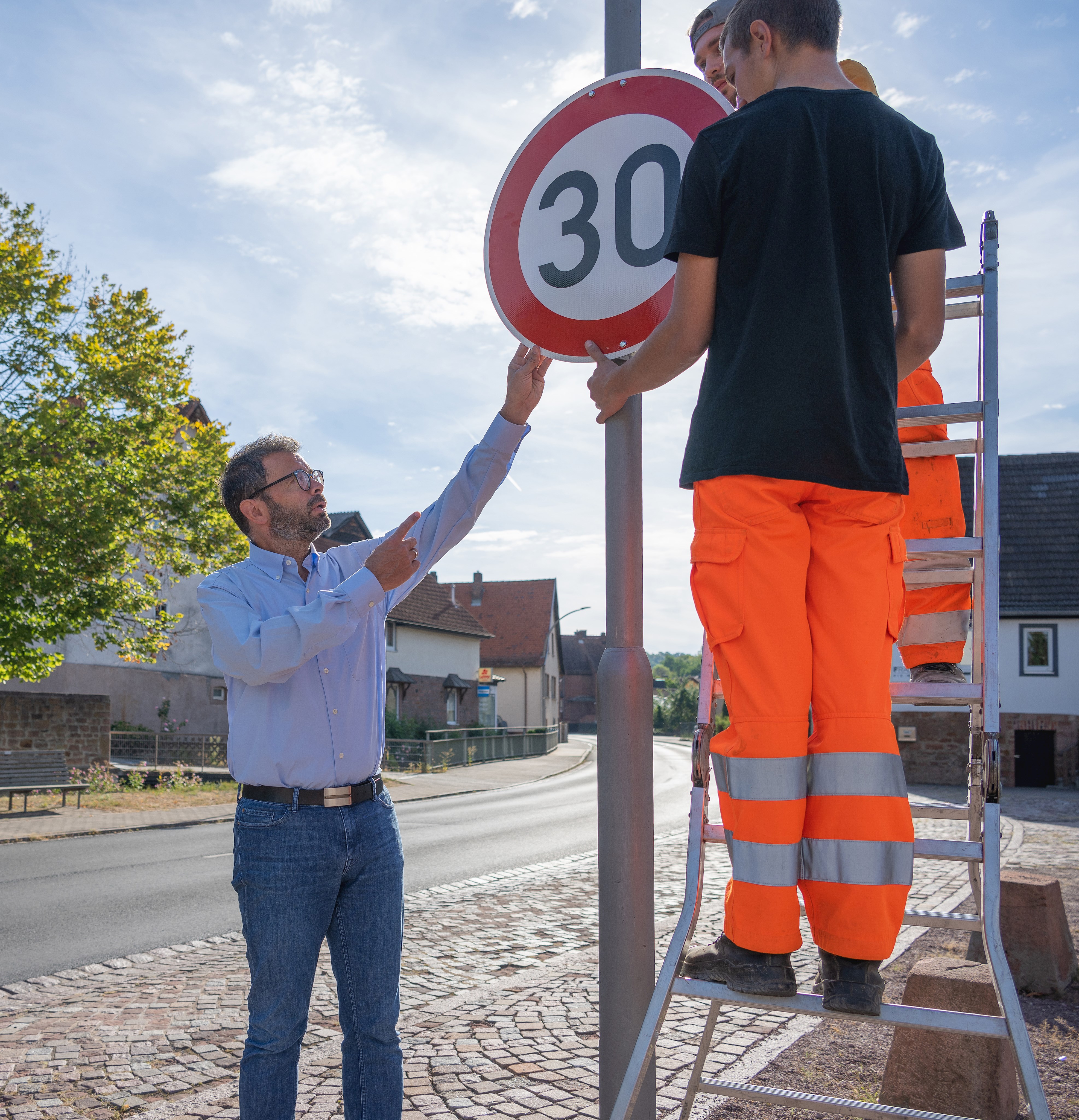 Um die Anwohner vor Lärm zu schützen, hat wurde eine Geschwindigkeitsreduzierung auf Tempo 30 auf einem drei Kilometer langen Teilstück der Ortsdurchfahrt Leidersbach angeordnet. Landrat Jens Marco Scherf (links) erklärte das Vorgehen am Dienstag vor Ort.